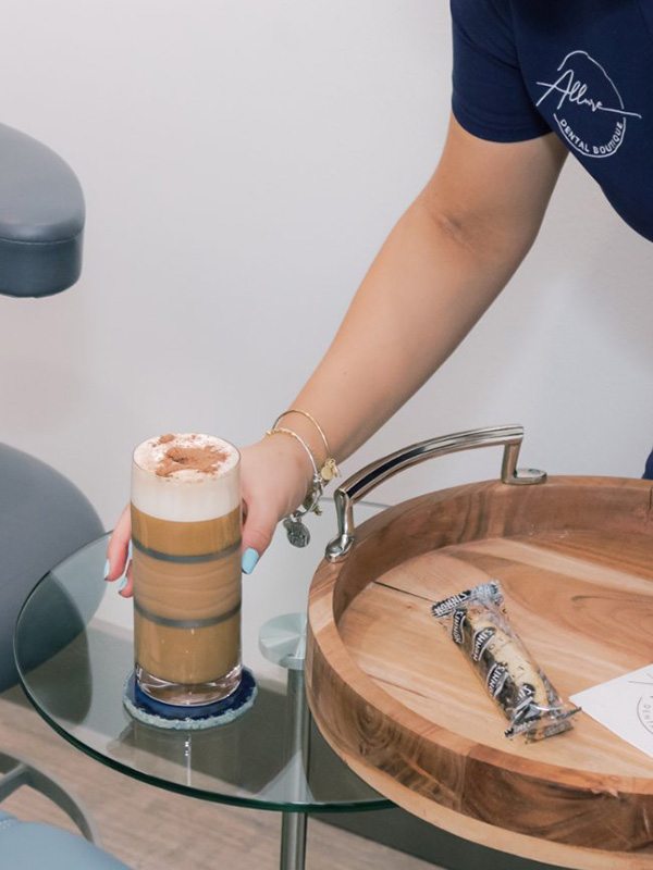 Dental team member placing a beverage and a pastry on a table