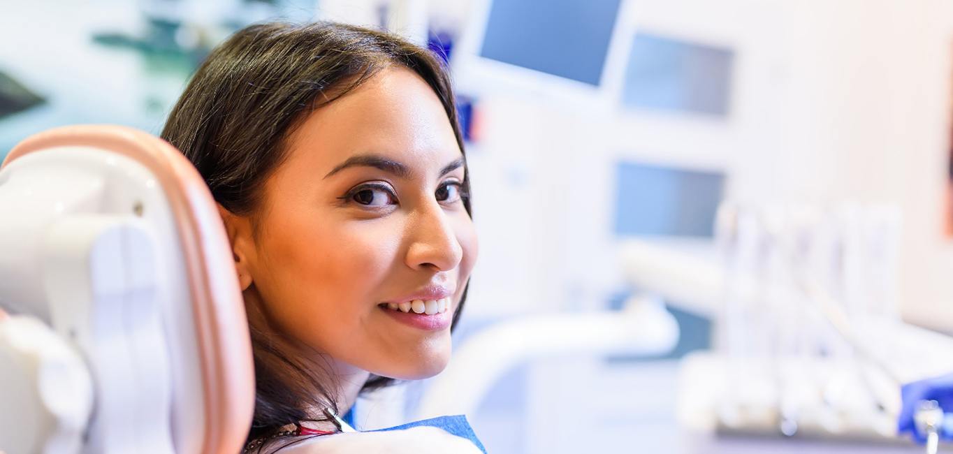 Female patient in dental chair looking back and smiling