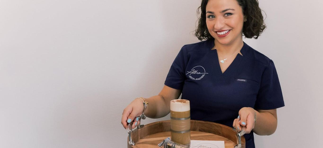 Lutz dental team member smiling and holding tray with beverage and pastry