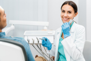 Dentist smiling at camera while holding a dental tool